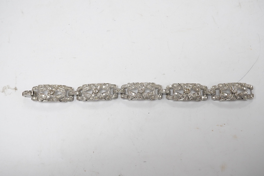 An early 20th century pierced platinum? and millegrain set diamond cluster bracelet, set with old round and eight cut stones, 17cm, gross weight 22.8 grams. Condition - fair to good